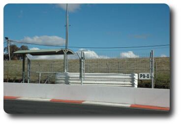 Cement barrier, wire fence around stand with a roof for shade
