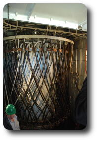 Vertical metal cylinder with heavy electrical cables hanging around it
