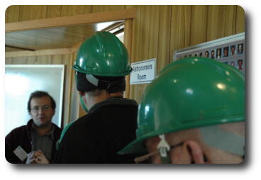 People in hall outside room labelled 