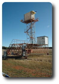 Wooden building atop scaffold tower on top of metal scaffolding on railway tracks