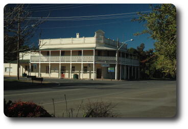 White, two storey building with wooden verandah on upper floor