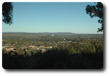 Nearby houses below to fields, bush and distant hills