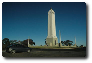 White, 4 story high column on top of hill