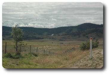 Bush scene, mountains in background, top of tracking dish just visible