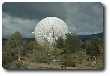 Photo of large tracking dish, underneath to camera, facing distant horizon