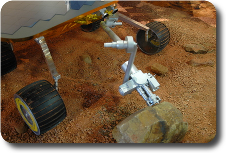 Mars rover in display of simulated surface of Mars; front view of manipulator arm
