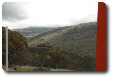 View up valley with rocky, grass covered hill side