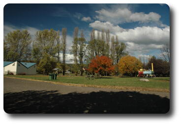 Cream and green building, trees with autumn colour in park