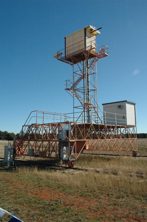 Wooden building atop scaffold tower on top of metal scaffolding on railway tracks