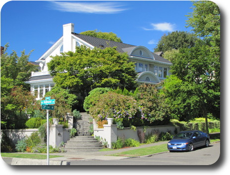 White painted house on Queen Anne, somewhat hidden by trees