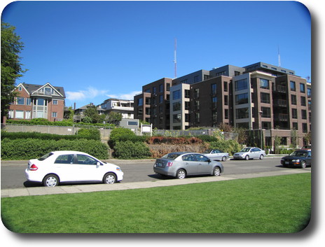 Modern apartment building beside an older style brick home.