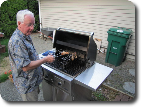 Man standing at gas grill cooking chicken