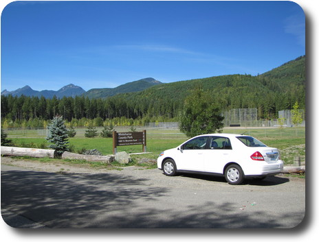 White car parked park with jagged mountains in the distance