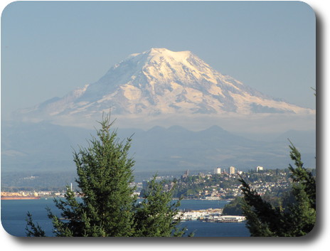 Snow capped volcanic mountain behind water