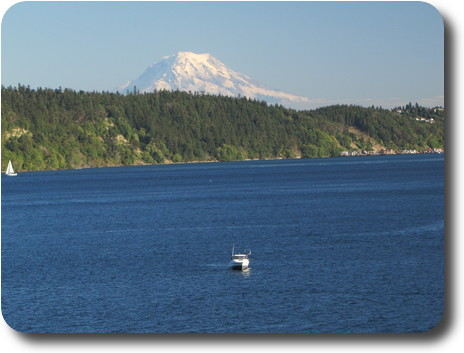 Mountain across water with boats on it