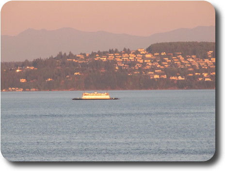 Ferry crossing in front of houses on distant hill
