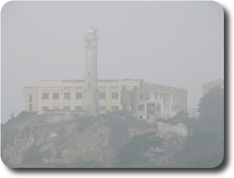 Rectangular building on top of rock with tower in front
