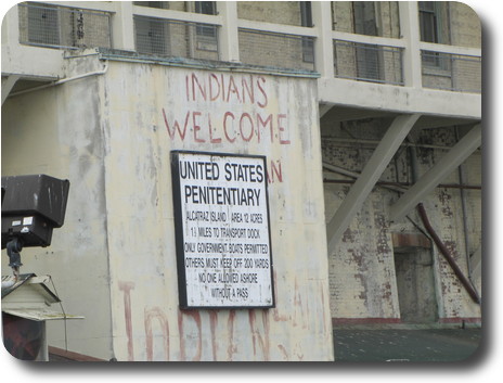 Cement wall with official sign and unofficial Indian sign