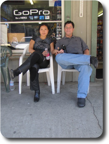 Woman and man sitting on chairs in front of convenience store