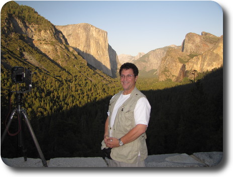 Man standing next to camera on tripod