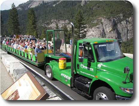 Prime mover with flat trailer seating tourists with a park ranger guide