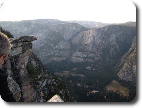Looking down into valley with trees, then cliffs behind