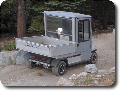 Gray park vehicle with tray on back, small wheels