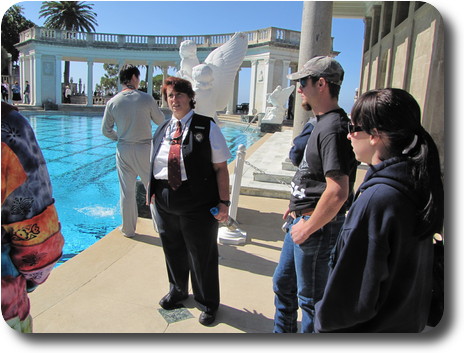 People around pool, with white marble statues and colonades