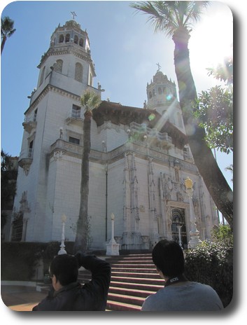 Front of tall, white building with twin towers and stairs up to the front