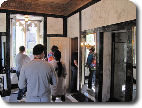 People walking out the door, reflected in nearby mirror