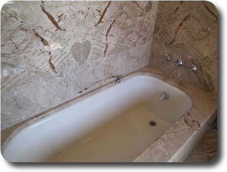 Bath in marble surround, which includes a heart shape in the pattern