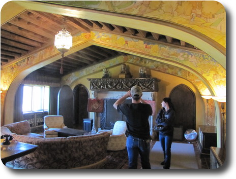 Large room, windows down far side, with sofas and a vaulted/cathedral style ceiling