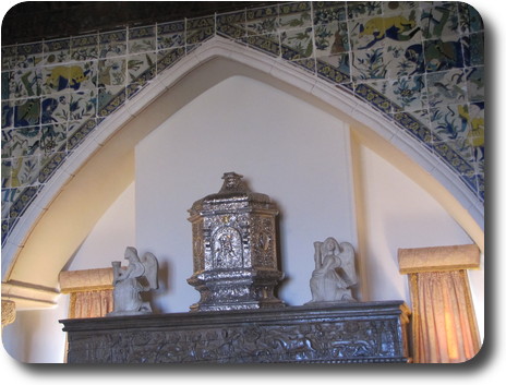 Silver tabernacle (little house) with a statue of angels on each side, over fireplace