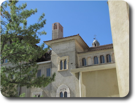 Rough finished cement walls with a tower peeking over the roof