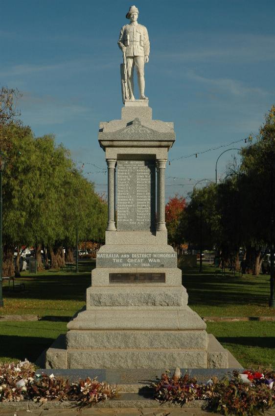 Gray stone structure, topped with a statue of soldier holding gun, butt to ground