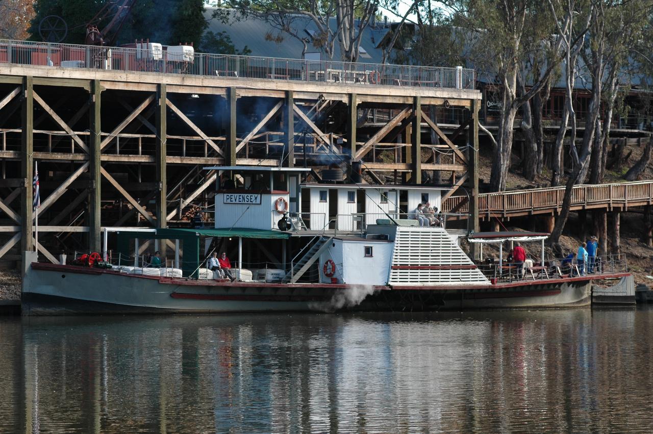 Paddle wheeler smoking and starting to leave the wharf