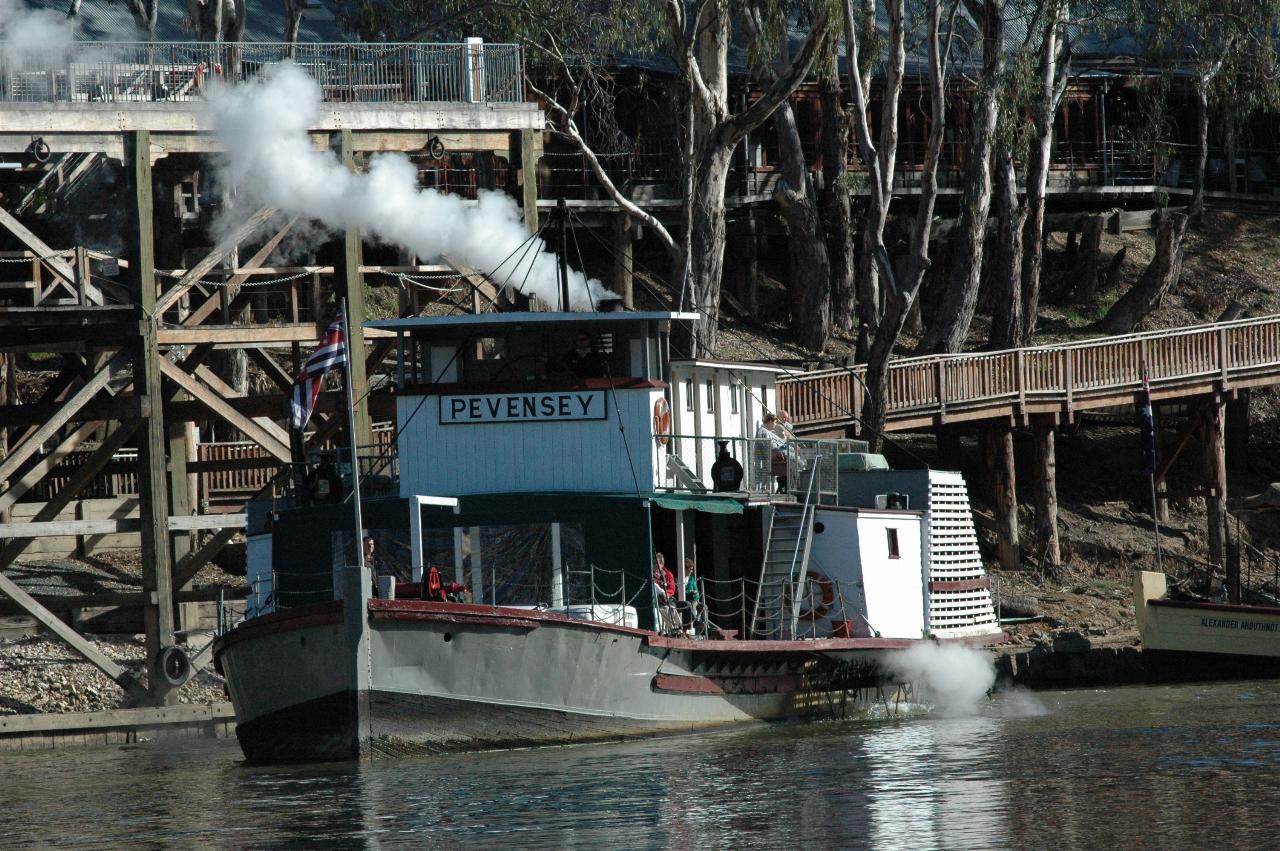 Paddle wheeler moving away from wharf, starting to make U turn
