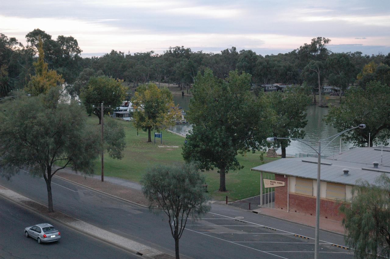 View from bridge over road, to park area along the river bank