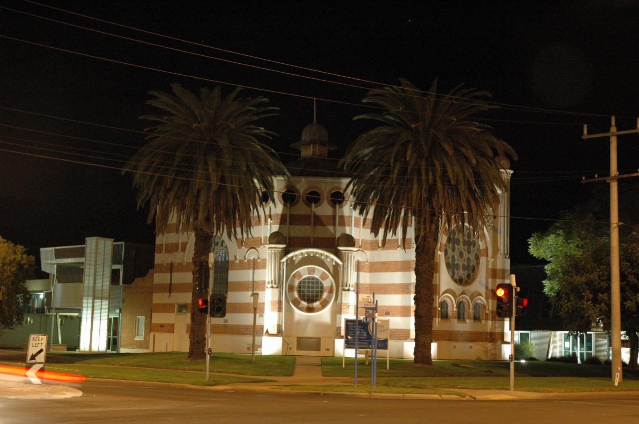 Hexagonal, horizontal striped church floodlit for night
