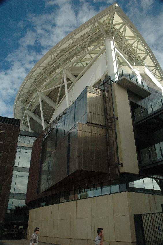 Large structure behind small people, rectangular boxes and much steelwork