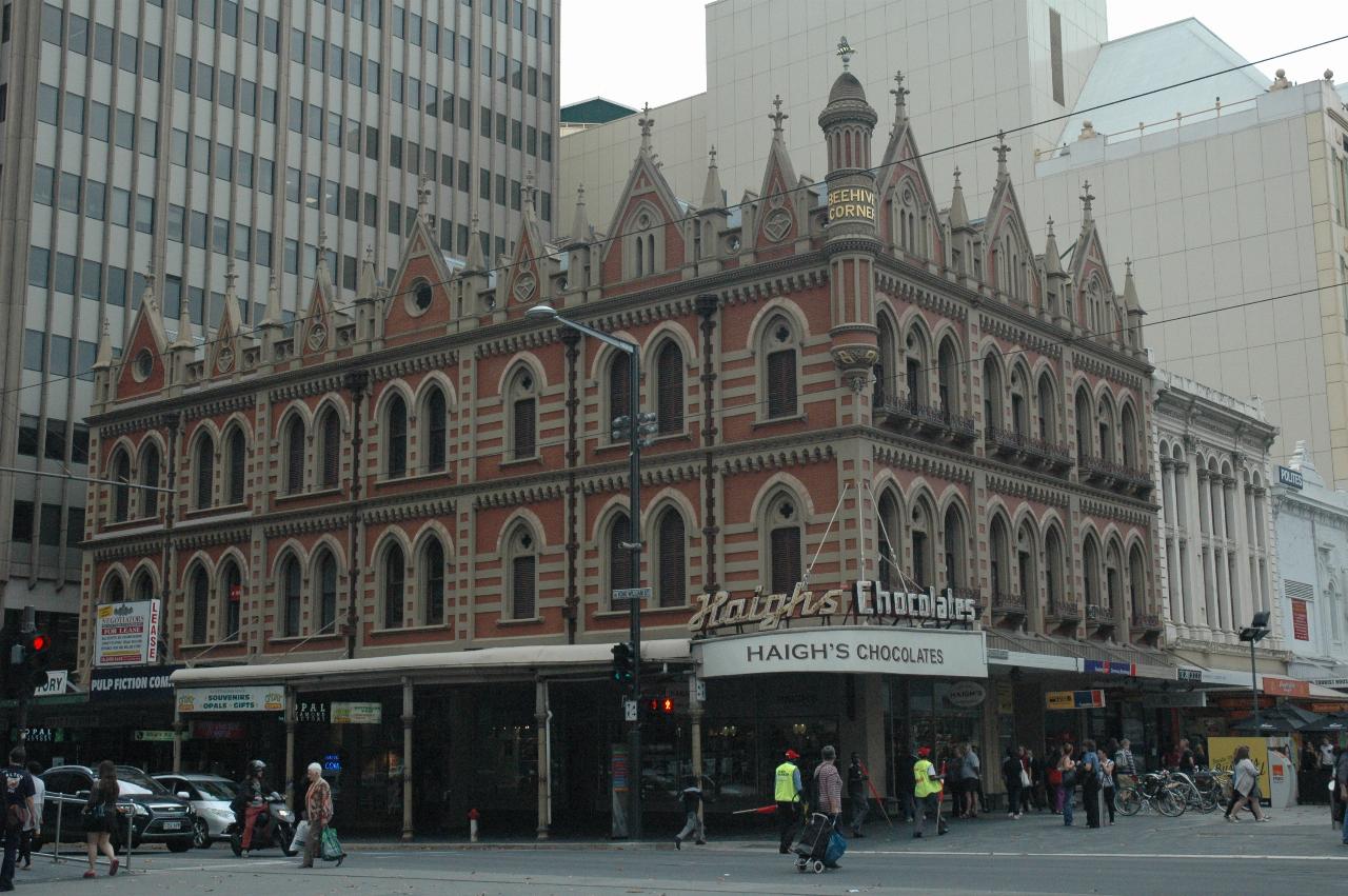 Three storey corner building, with orange walls with white stone horizontal stripes