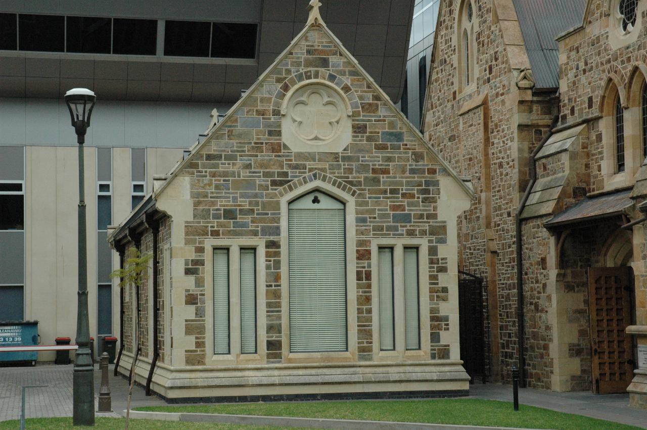 A very small stone church, with blinds on all the windows