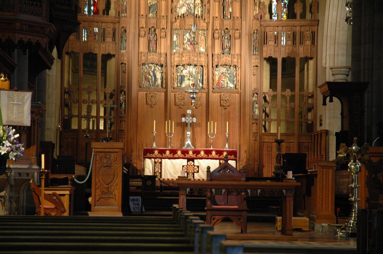 Altar and intricately carved wooden wall behind