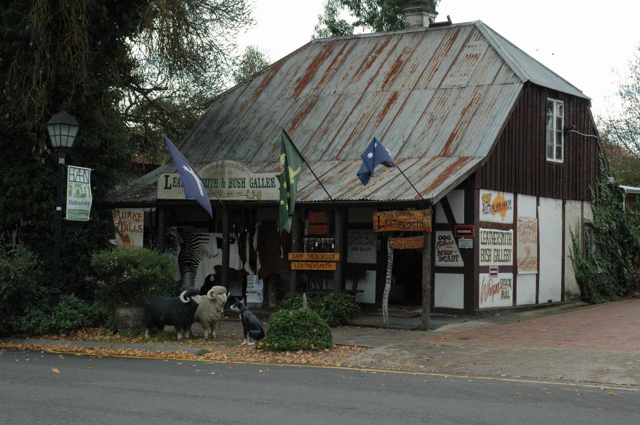 Old shop building, rusty roof, rough finished wood support, signs