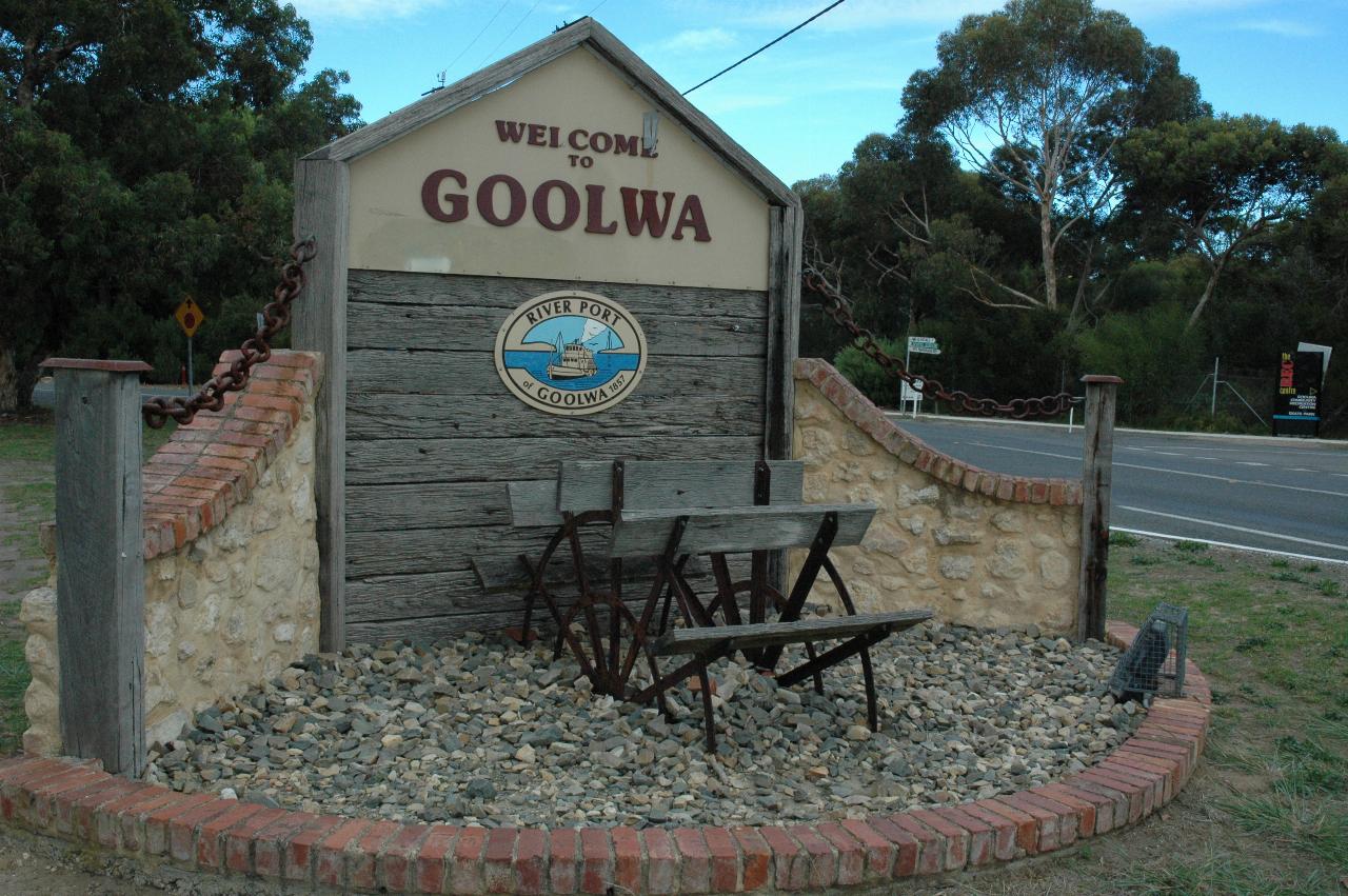Display with wooden wall, half buried paddle wheel in gravel at front