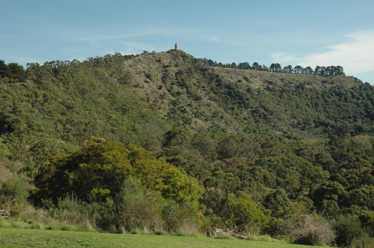 Stone tower visible on distant rim of volcanic crater