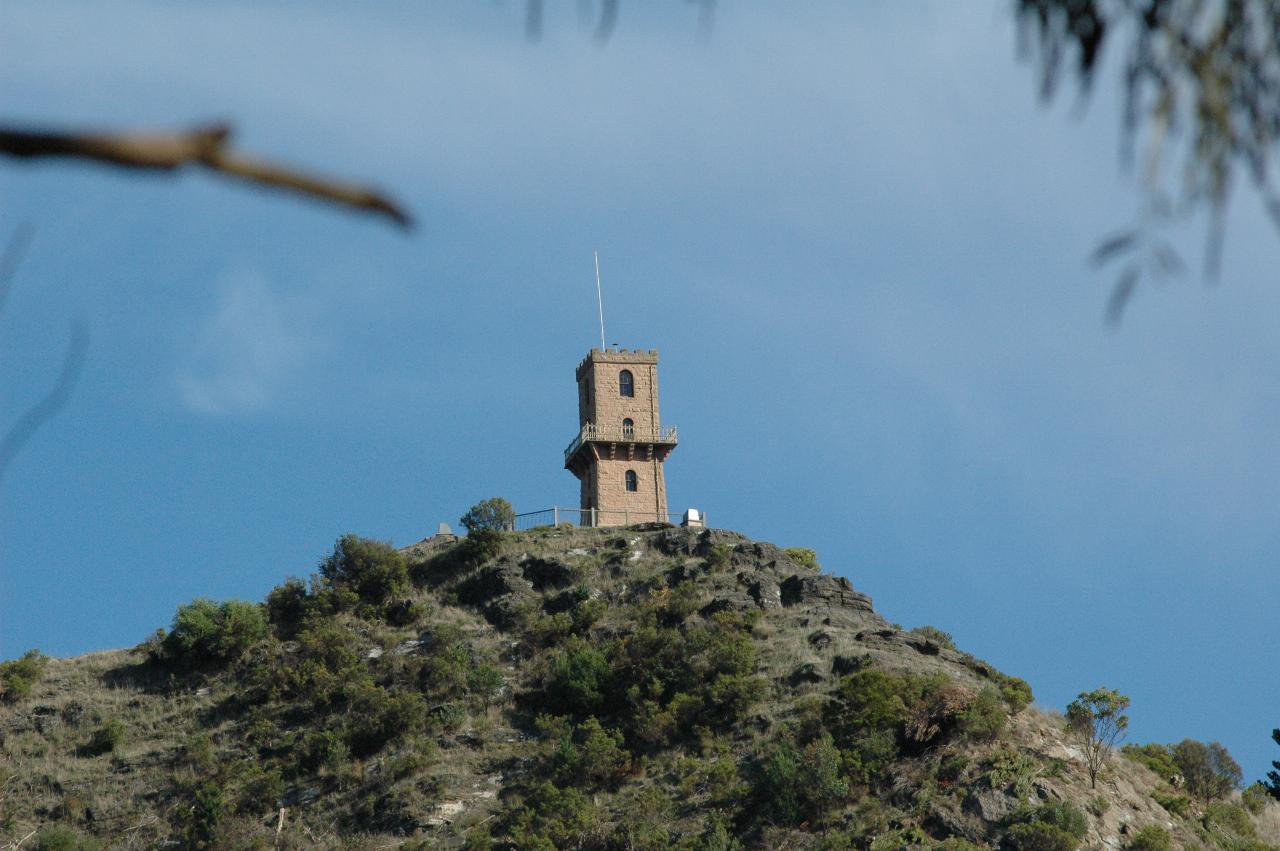 Brick tower perched on top of hill which is part of the crater wall