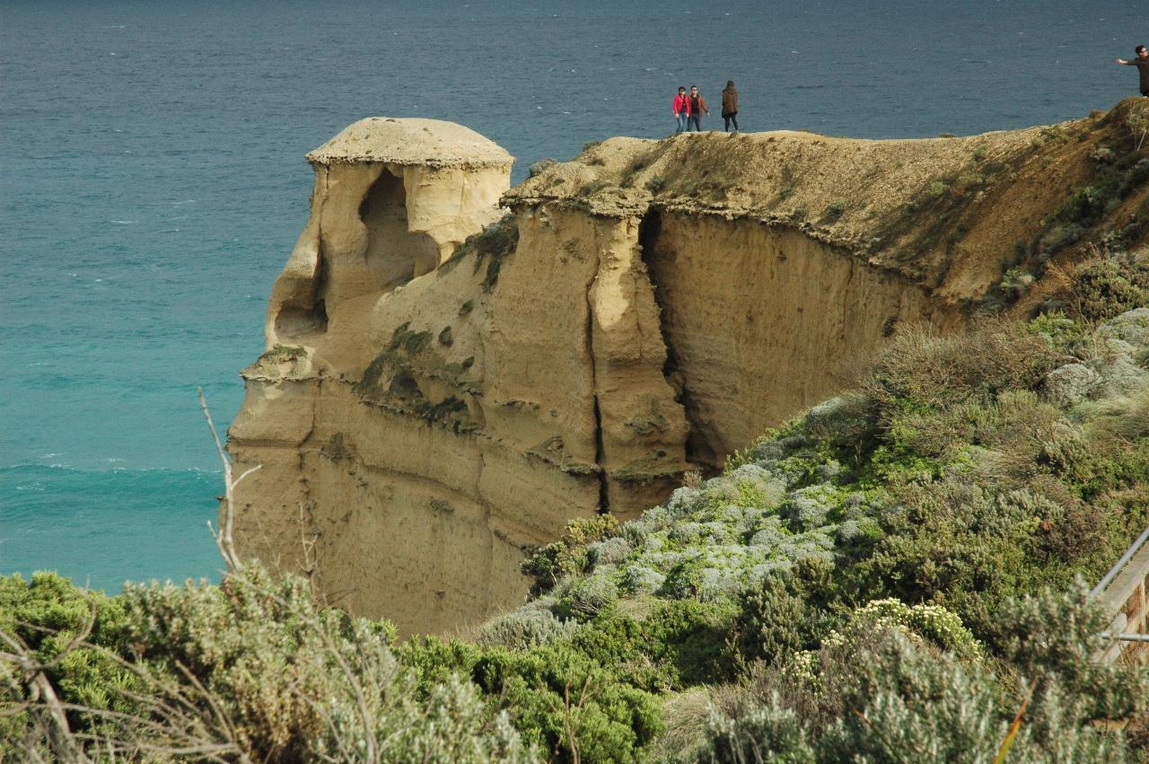 People in the do not enter area, but seen from afar and adjacent to eroding side of headland