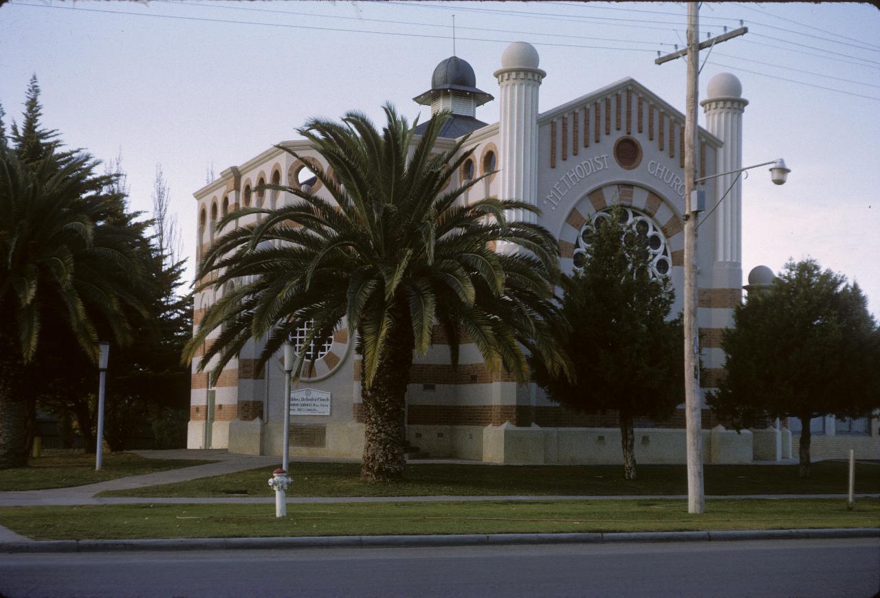 Tall, cross shaped church with alternating white and orange/brown layers