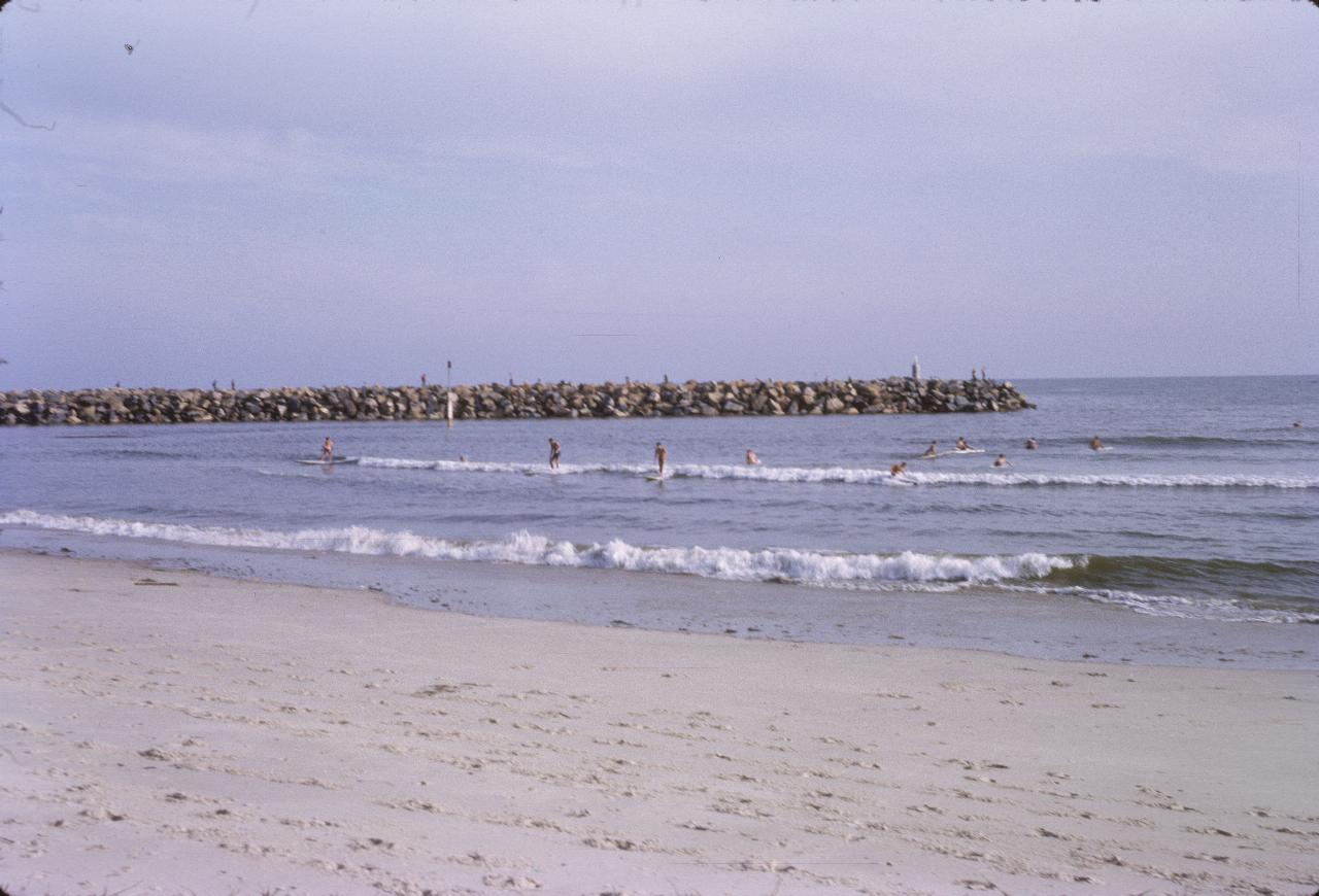 Surfers on very small waves near the beach